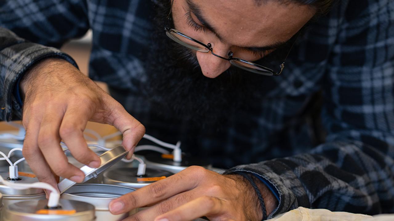 Male researcher examining small metal cups